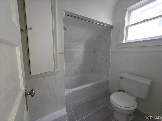 1618 16th St, Niagara Falls, NY 14305 - full bath with tile walls, toilet, shower / bath combination, vaulted ceiling, and tile patterned flooring