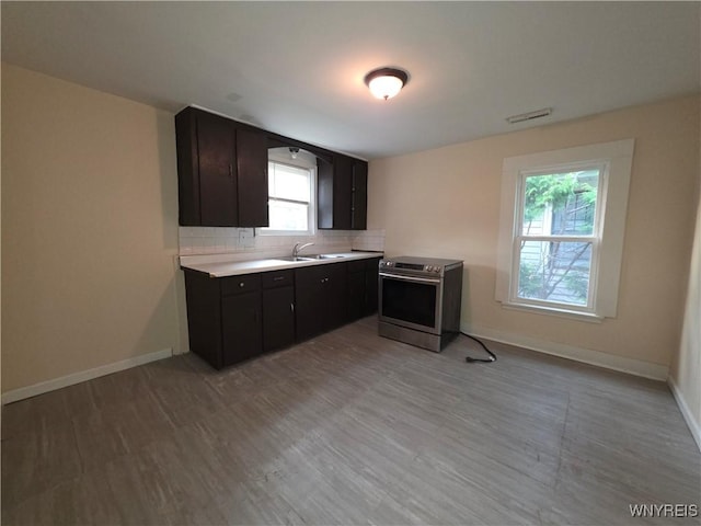 1618 16th St, Niagara Falls, NY 14305 - kitchen featuring stainless steel range with electric stovetop, a sink, light countertops, tasteful backsplash, and baseboards