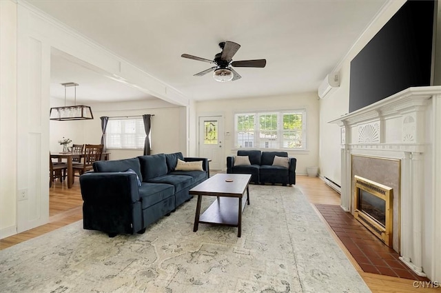 53 University Ave, Hamilton, NY 13346 - living area with a baseboard radiator, a ceiling fan, a fireplace with flush hearth, wood finished floors, and a wall mounted AC