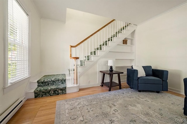 53 University Ave, Hamilton, NY 13346 - living area featuring a baseboard heating unit, stairway, crown molding, wood finished floors, and baseboards
