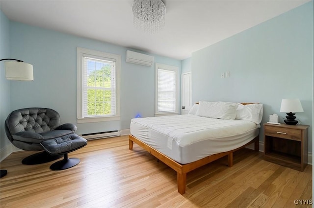53 University Ave, Hamilton, NY 13346 - bedroom with an AC wall unit, a baseboard heating unit, light wood-type flooring, and baseboards