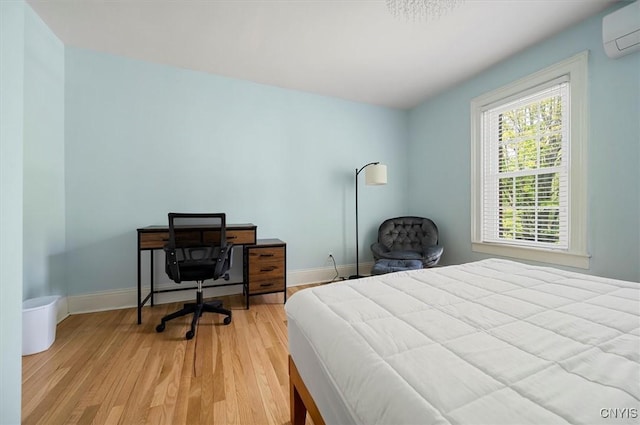 53 University Ave, Hamilton, NY 13346 - bedroom with a wall unit AC, light wood finished floors, and baseboards