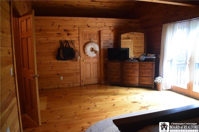 6615 Java Lake Rd, Arcade, NY 14009 - bedroom with multiple windows, light wood-style floors, and wood walls