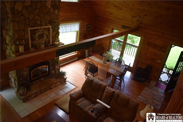 6615 Java Lake Rd, Arcade, NY 14009 - living area with plenty of natural light, wooden walls, wood finished floors, a high ceiling, and a glass covered fireplace