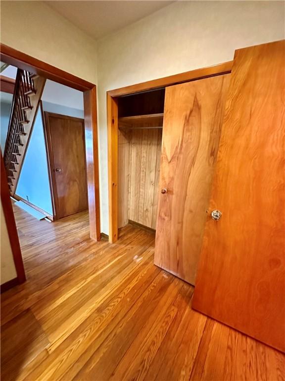 6956 E Washington St, Bath, NY 14810 - unfurnished bedroom featuring wood finished floors and a closet