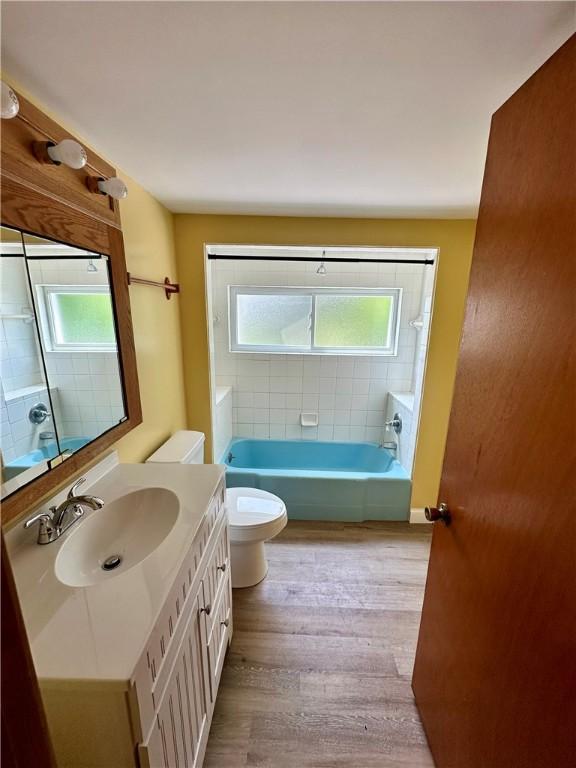 6956 E Washington St, Bath, NY 14810 - full bath with toilet, vanity, healthy amount of natural light, and wood finished floors
