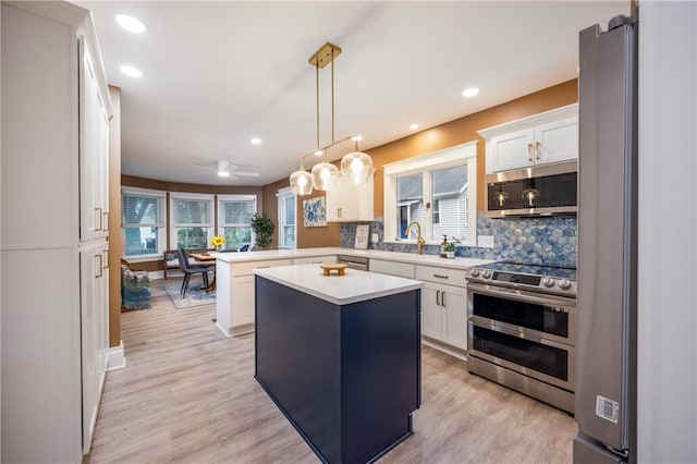 40 Washington Rd, Pittsford, NY 14534 - kitchen with stainless steel appliances, a peninsula, light countertops, plenty of natural light, and recessed lighting