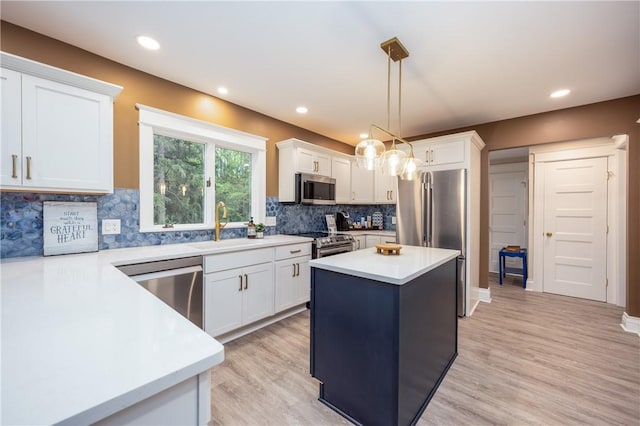 40 Washington Rd, Pittsford, NY 14534 - kitchen with stainless steel appliances, a sink, light countertops, white cabinets, and light wood-type flooring