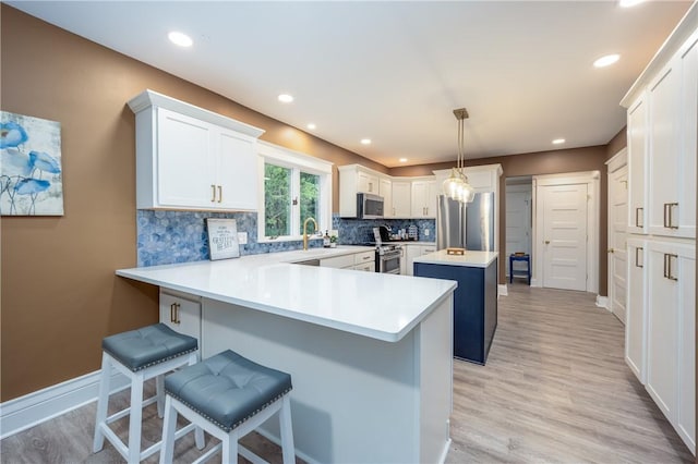 40 Washington Rd, Pittsford, NY 14534 - kitchen with appliances with stainless steel finishes, a kitchen island, a peninsula, backsplash, and a kitchen breakfast bar
