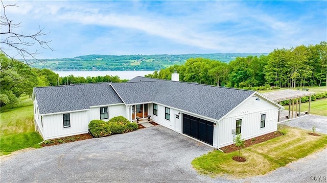 4500 W Lake Rd, Niles, NY 13152 - modern inspired farmhouse featuring an attached garage, asphalt driveway, a chimney, and roof with shingles
