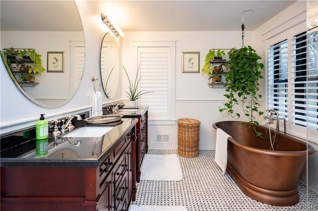 4500 W Lake Rd, Niles, NY 13152 - bathroom featuring double vanity, a soaking tub, a wainscoted wall, and tile walls