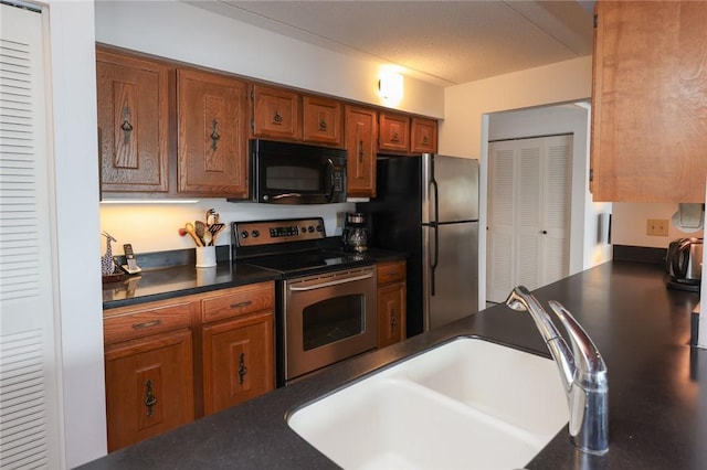 135 Cliffside Dr, South Bristol, NY 14424 - kitchen with appliances with stainless steel finishes, a sink, dark countertops, and brown cabinets