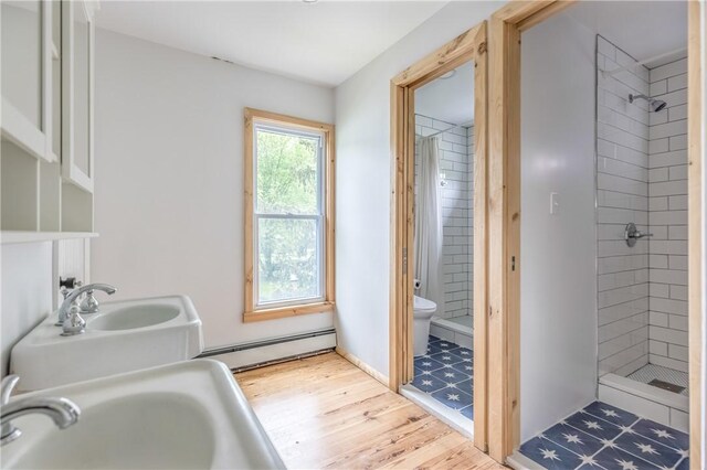 39 Middle St, Hancock, NY 13756 - full bath featuring baseboard heating, toilet, a shower stall, wood finished floors, and a sink