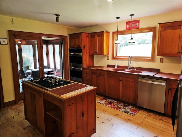 139 Pheasant Run Rd, Middlefield, NY 13326 - kitchen featuring tile countertops, stainless steel appliances, a sink, and light wood-style floors