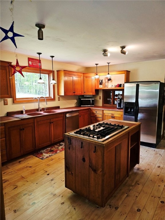 139 Pheasant Run Rd, Middlefield, NY 13326 - kitchen featuring appliances with stainless steel finishes, a sink, light wood finished floors, and decorative light fixtures