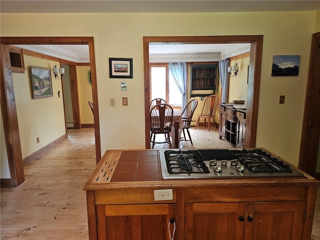 139 Pheasant Run Rd, Middlefield, NY 13326 - kitchen featuring light wood-style floors, stainless steel gas cooktop, baseboards, brown cabinetry, and a baseboard heating unit