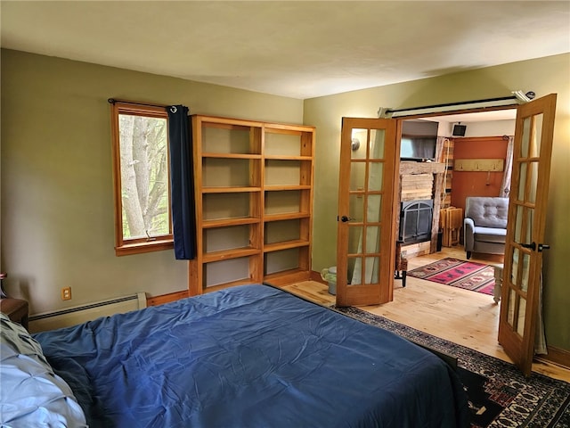 139 Pheasant Run Rd, Middlefield, NY 13326 - bedroom with a baseboard heating unit, wood finished floors, and french doors