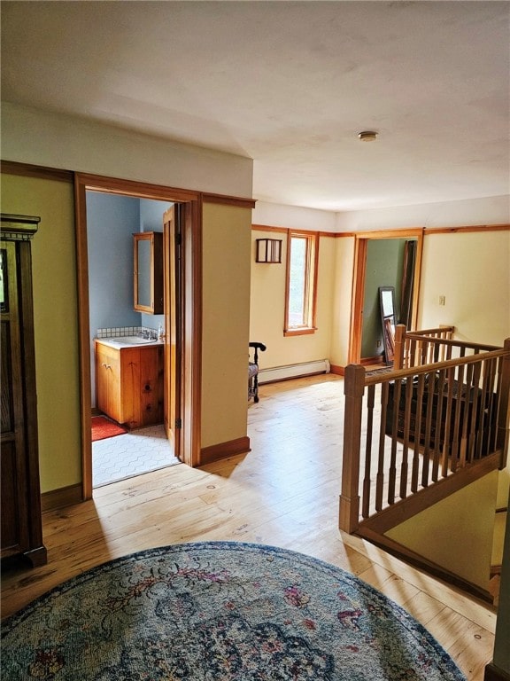 139 Pheasant Run Rd, Middlefield, NY 13326 - hallway with a baseboard heating unit, light wood finished floors, baseboards, and an upstairs landing