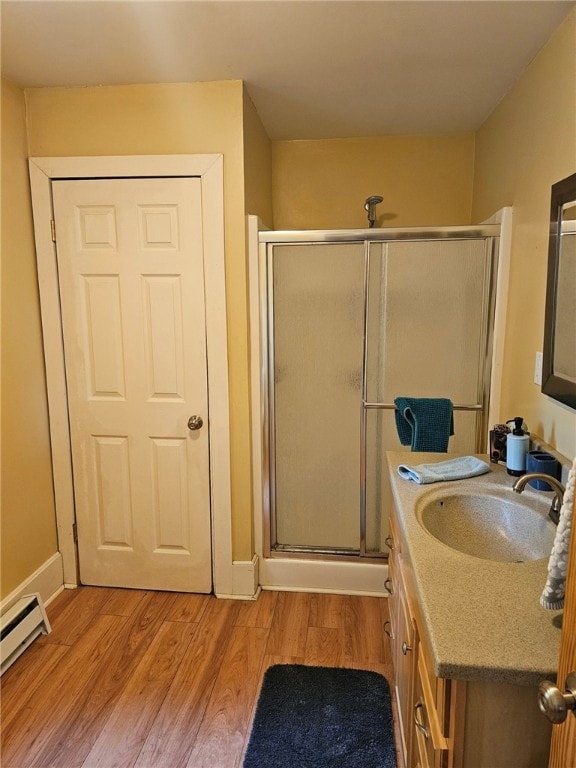139 Pheasant Run Rd, Middlefield, NY 13326 - full bath with vanity, a stall shower, wood finished floors, and a baseboard heating unit