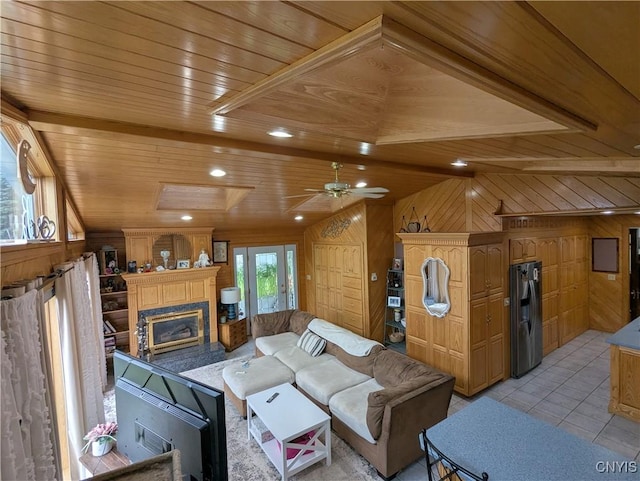 2976 Cataract St, Denmark, NY 13626 - living area featuring wooden walls, lofted ceiling, wooden ceiling, a glass covered fireplace, and light tile patterned flooring