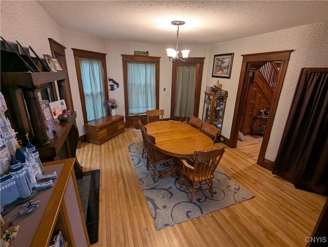 2976 Cataract St, Denmark, NY 13626 - dining area featuring a chandelier, light wood-style floors, a textured ceiling, and wallpapered walls