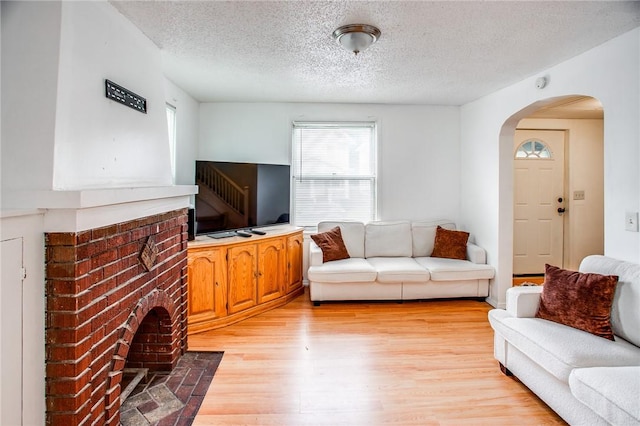 239 Weyl, Rochester, NY 14621 - living room with arched walkways, light wood-style flooring, and a textured ceiling