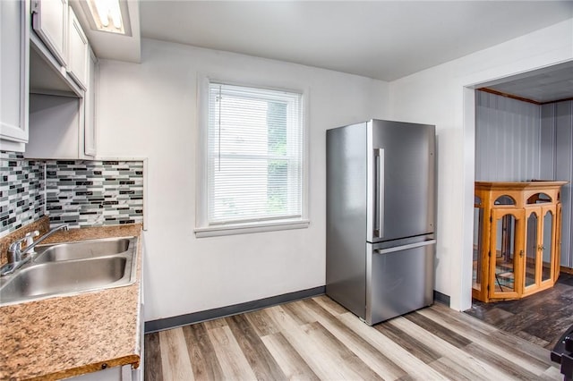 239 Weyl, Rochester, NY 14621 - kitchen featuring freestanding refrigerator, a sink, light wood-style flooring, tasteful backsplash, and white cabinetry