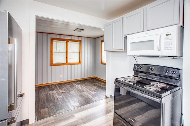 239 Weyl, Rochester, NY 14621 - kitchen featuring white microwave, black range with electric stovetop, light wood-style floors, and baseboards