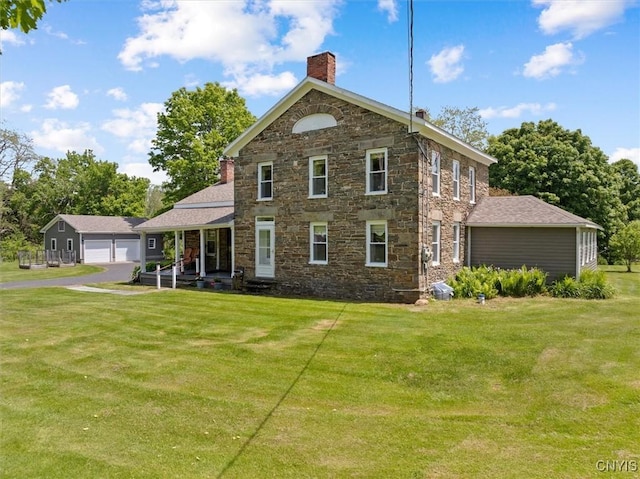 8796 State Highway 12, Sherburne, NY 13460 - view of front of property with a chimney, stone siding, a front lawn, and a detached garage