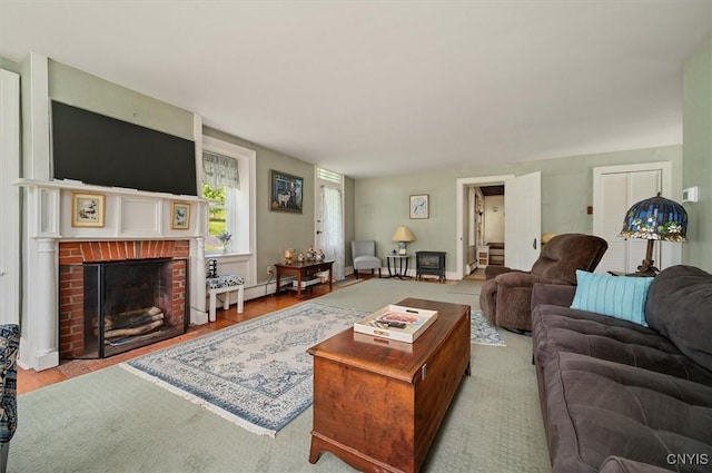 8796 State Highway 12, Sherburne, NY 13460 - living room with a brick fireplace, baseboard heating, and wood finished floors