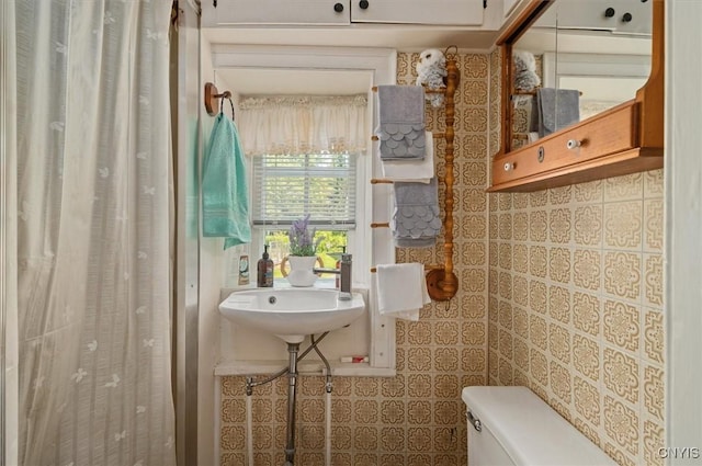 8796 State Highway 12, Sherburne, NY 13460 - bathroom featuring toilet, tile walls, a sink, and a shower with shower curtain