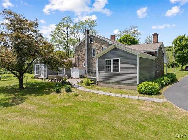 8796 State Highway 12, Sherburne, NY 13460 - rear view of property with a lawn, a chimney, and stone siding