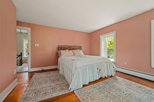 8796 State Highway 12, Sherburne, NY 13460 - bedroom featuring wood-type flooring, baseboards, and a baseboard heating unit