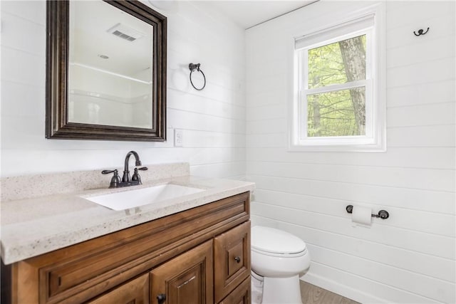 2712 Silver Lake Rd, Hancock, NY 13783 - bathroom featuring vanity, toilet, and wood walls