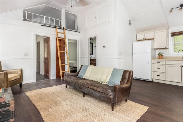 2712 Silver Lake Rd, Hancock, NY 13783 - living room with wainscoting, a barn door, dark wood-style floors, ceiling fan, and high vaulted ceiling
