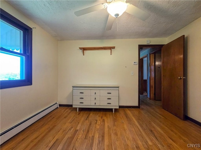 3636 Kennedy Rd, Lafayette, NY 13084 - spare room with baseboard heating, a textured ceiling, wood finished floors, baseboards, and a ceiling fan