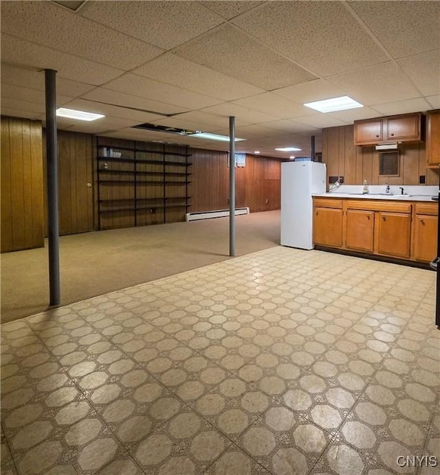 3636 Kennedy Rd, Lafayette, NY 13084 - finished below grade area with light flooring, freestanding refrigerator, a baseboard radiator, a paneled ceiling, and wood walls