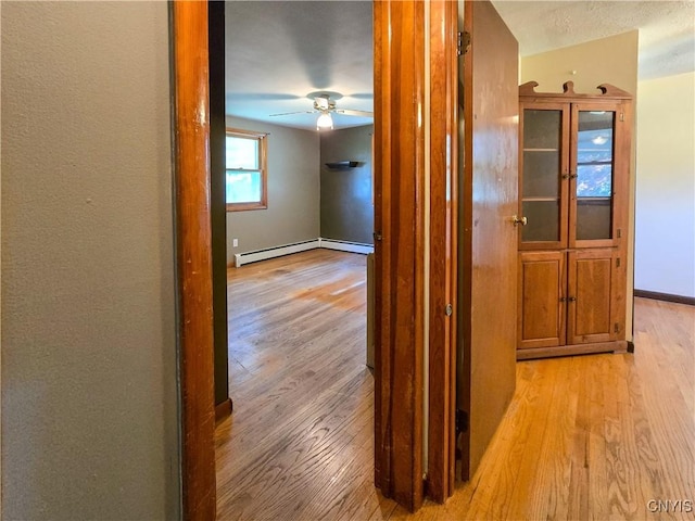 3636 Kennedy Rd, Lafayette, NY 13084 - corridor featuring light wood finished floors, baseboards, and a baseboard radiator