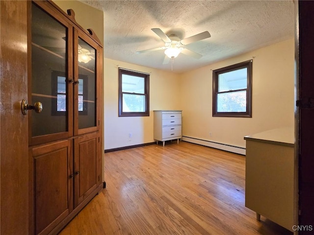 3636 Kennedy Rd, Lafayette, NY 13084 - unfurnished room featuring baseboard heating, a textured ceiling, light wood-style flooring, baseboards, and a ceiling fan