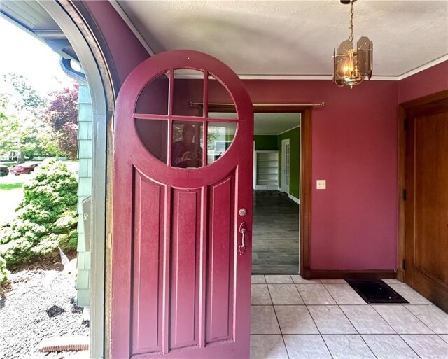 966 W Church St, Elmira, NY 14905 - entryway with light tile patterned floors, a chandelier, a textured ceiling, and baseboards