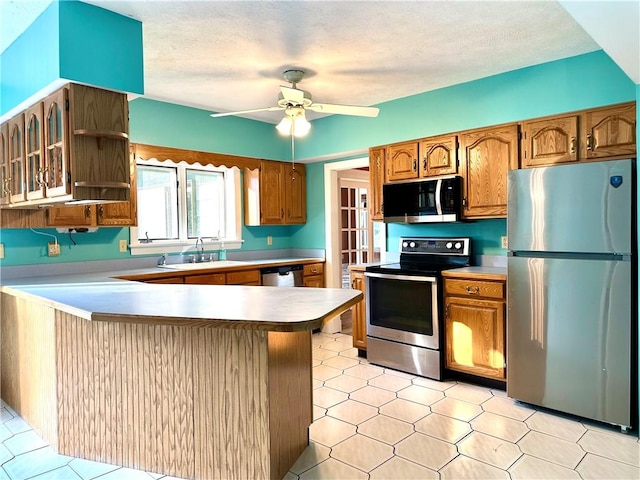 966 W Church St, Elmira, NY 14905 - kitchen with stainless steel appliances, a peninsula, brown cabinets, a ceiling fan, and a textured ceiling