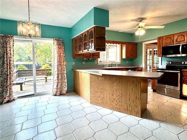 966 W Church St, Elmira, NY 14905 - kitchen with stainless steel appliances, a peninsula, a chandelier, glass insert cabinets, and ceiling fan