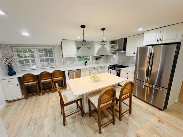 11 Laureldale Dr, Pittsford, NY 14534 - kitchen with appliances with stainless steel finishes, wall chimney exhaust hood, light wood-style floors, white cabinetry, and backsplash
