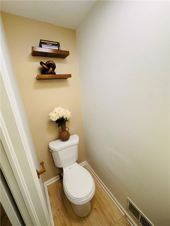 11 Laureldale Dr, Pittsford, NY 14534 - bathroom with wood finished floors, toilet, and baseboards