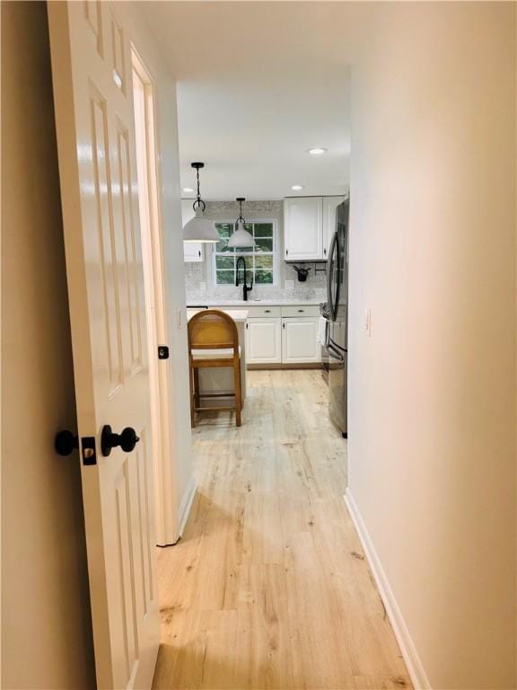 11 Laureldale Dr, Pittsford, NY 14534 - hallway featuring light wood finished floors, baseboards, recessed lighting, and a sink
