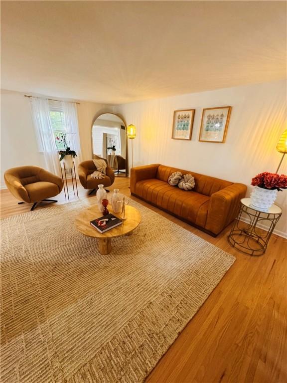 11 Laureldale Dr, Pittsford, NY 14534 - living area featuring arched walkways, wood finished floors, and baseboards