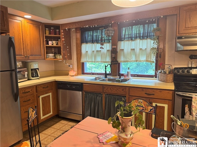 162 Sturges St, Jamestown, NY 14701 - kitchen with a sink, stainless steel appliances, under cabinet range hood, brown cabinets, and light countertops