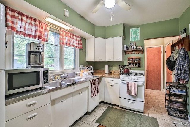 117 Stutzman Rd, Lancaster, NY 14026 - kitchen with white gas stove, stainless steel microwave, white cabinets, a ceiling fan, and a sink