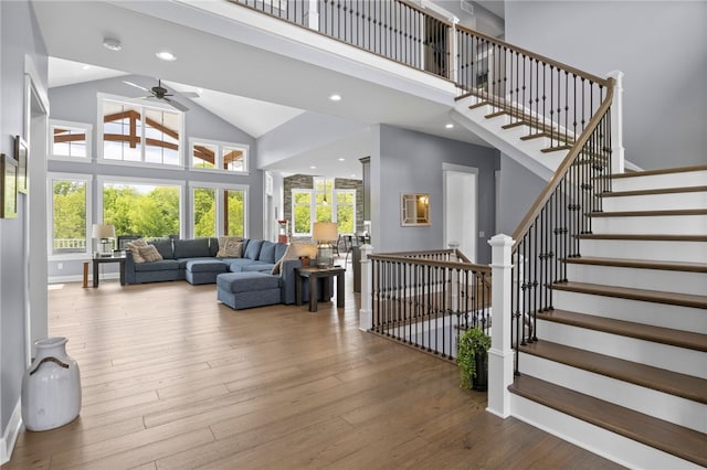 1915 Factors Walk, West Bloomfield, NY 14475 - living room with high vaulted ceiling, baseboards, ceiling fan, wood finished floors, and stairs