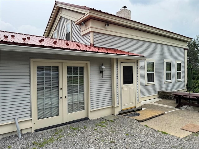 1604 Moland Rd, Alfred, NY 14803 - rear view of house featuring french doors, a patio, metal roof, and a chimney